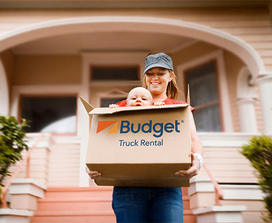 Happy mom moving with baby in Budget Truck boxes