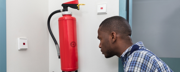 Man testing fire extinguisher for daylight savings time 