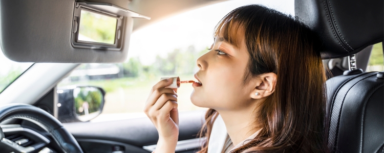 woman driving distracted putting on makeup