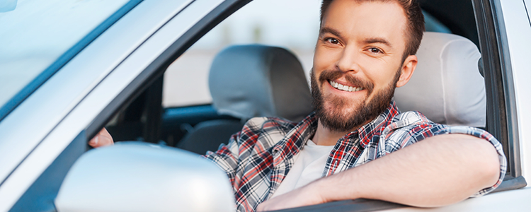 Smiling man in his new car.